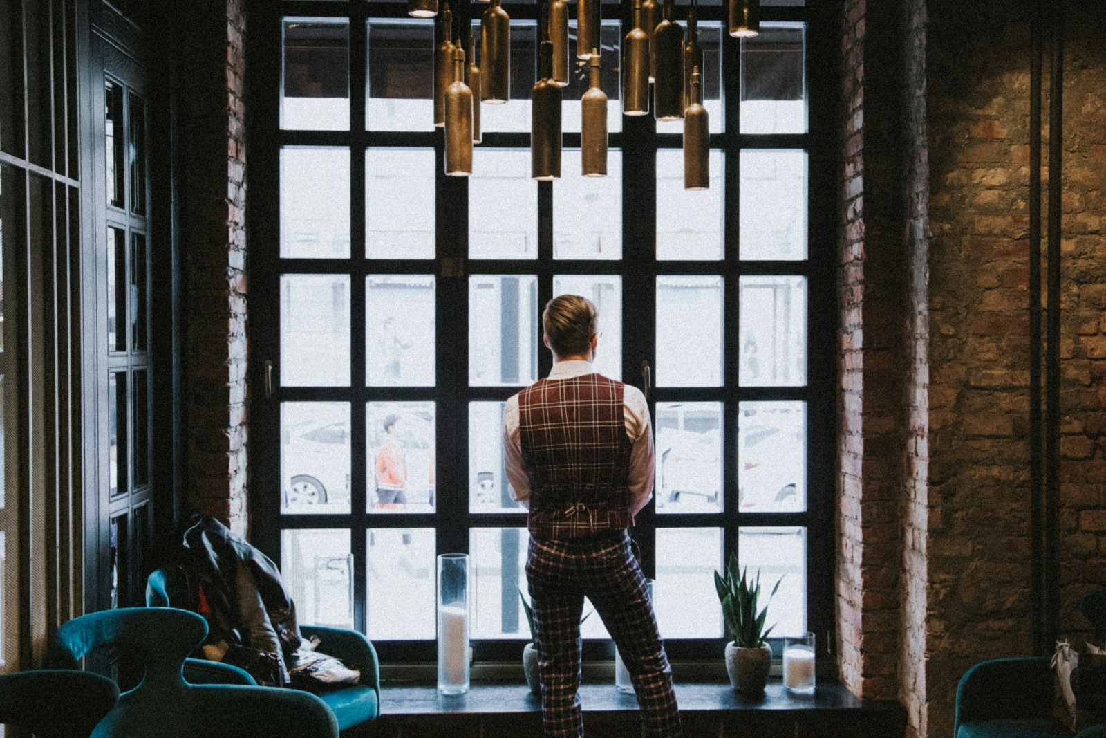 Unidentifiable man looking out of a window in an upmarket hotel